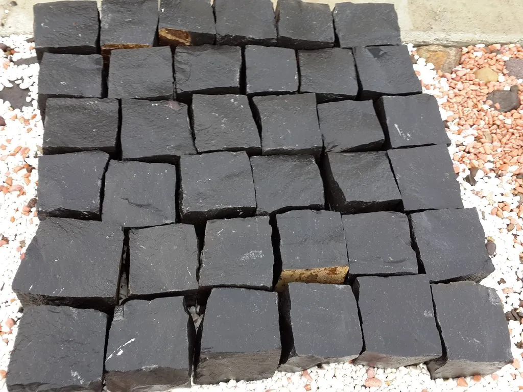 Black basalt setts laid dry as a sample panel, showing their natural split faces