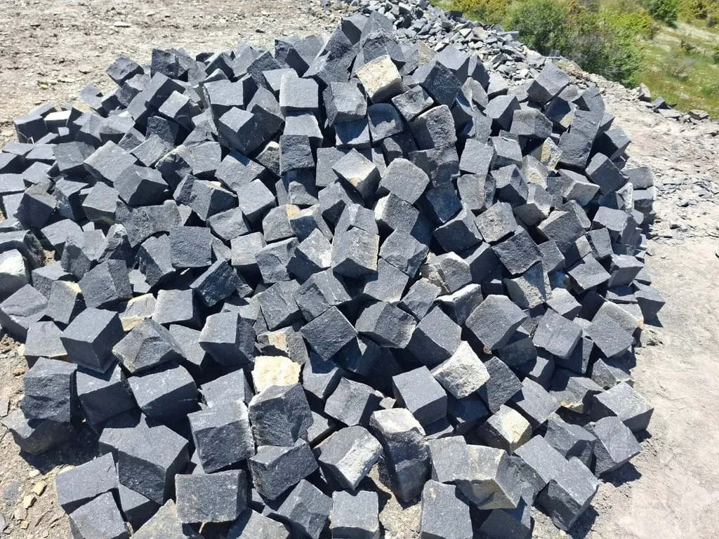 Freshly split black basalt setts stockpiled at the quarry