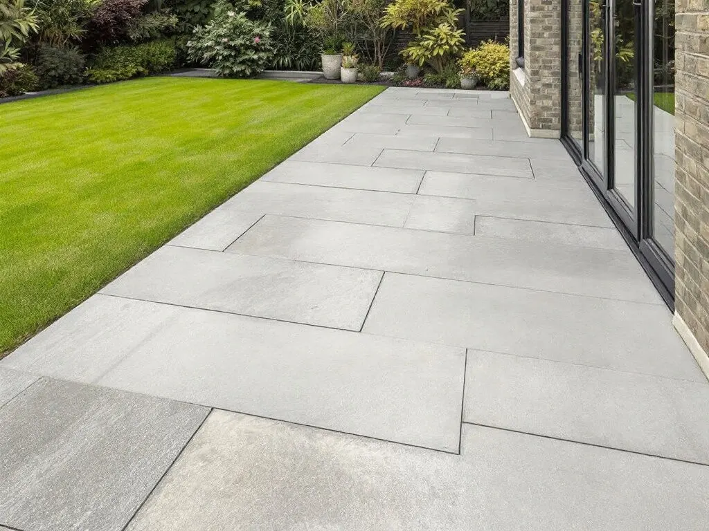 Light grey large-format porcelain paving on a garden patio