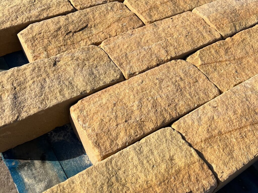 Tumbled buff sandstone walling blocks with softened arrises